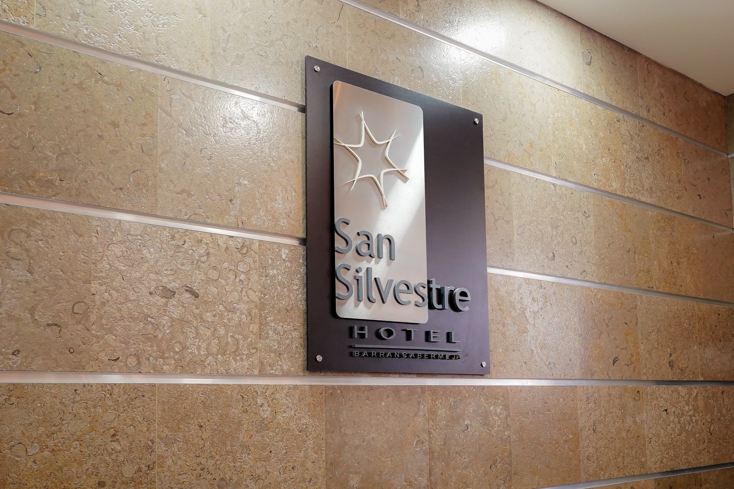 Placa del Hotel San Silvestre sobre el muro de piedra del lobby